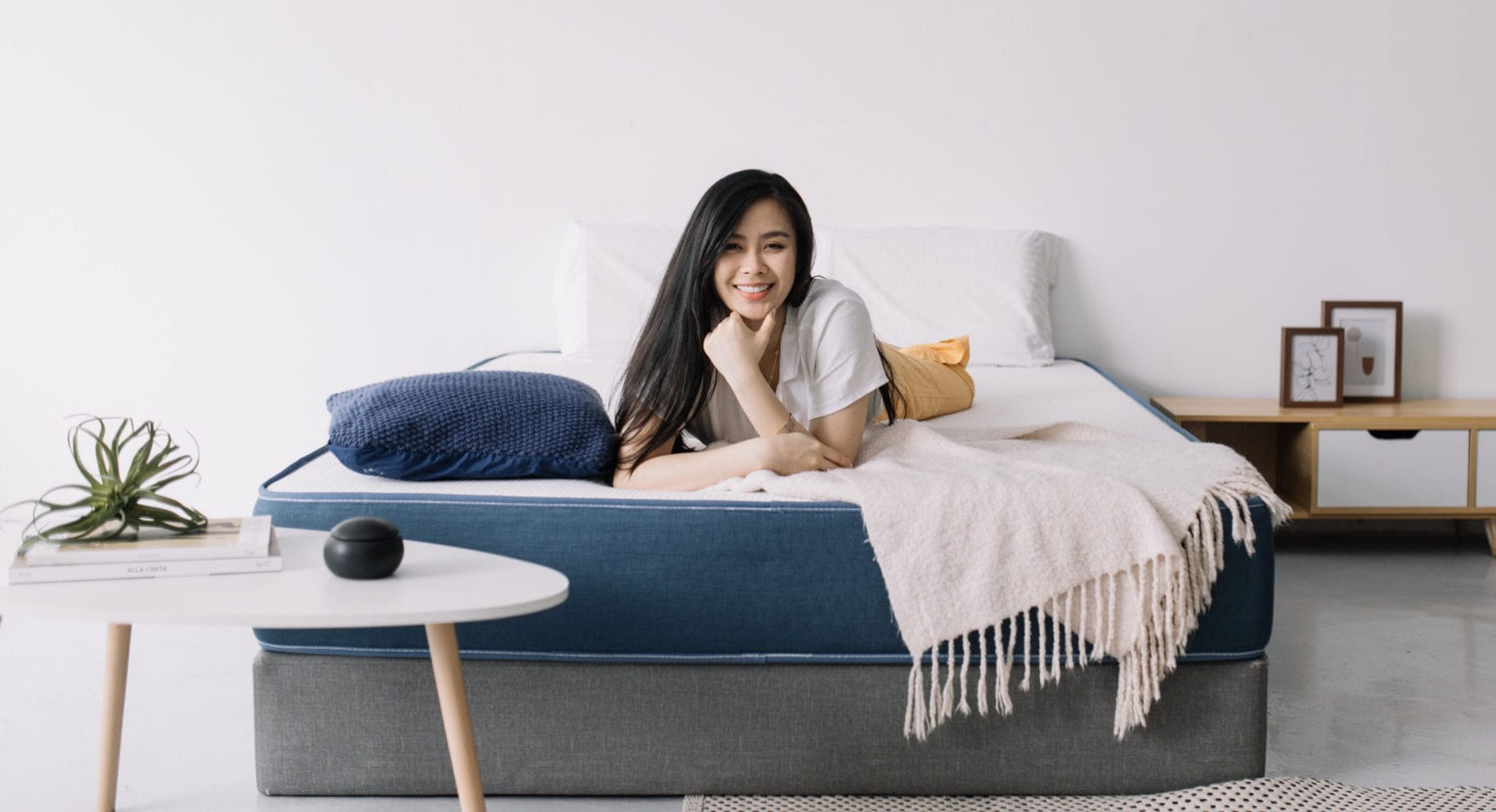 Woman relaxing on Kozynap mattress protector showcasing luxury comfort sleep experience