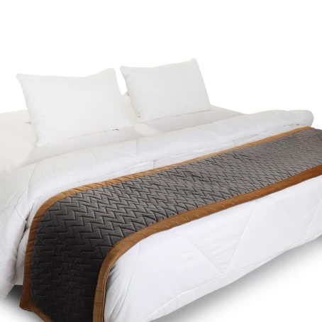 Charcoal grey bed runner with tan trim on a white bed
