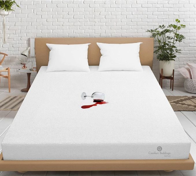 Mattress Protector on a bed protecting against a spilled glass of wine