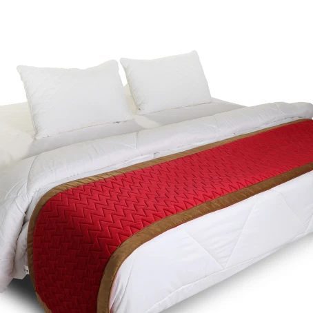Red bed runner with tan trim on a white bed