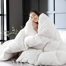 Woman hugging a soft fluffy duvet comforter on a bed